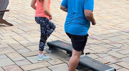 Two people exercising at MarkSpeakForm, Howell, Michigan, US, using step platforms outdoors.
