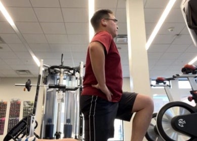 Man exercising in the gym at Marks Peak Form in Howell, Michigan, US with cycling machines and weights.