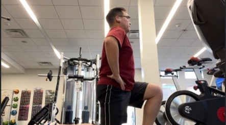 Man exercising in the gym at Marks Peak Form in Howell, Michigan, US with cycling machines and weights.