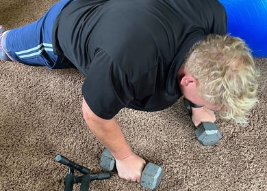 Strength training at Marks Peak Form in Howell, Michigan with dumbbells and stability ball on the floor.