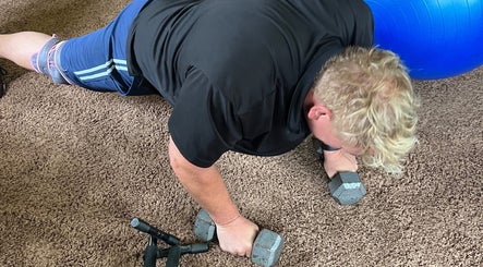 Strength training at Marks Peak Form in Howell, Michigan with dumbbells and stability ball on the floor.