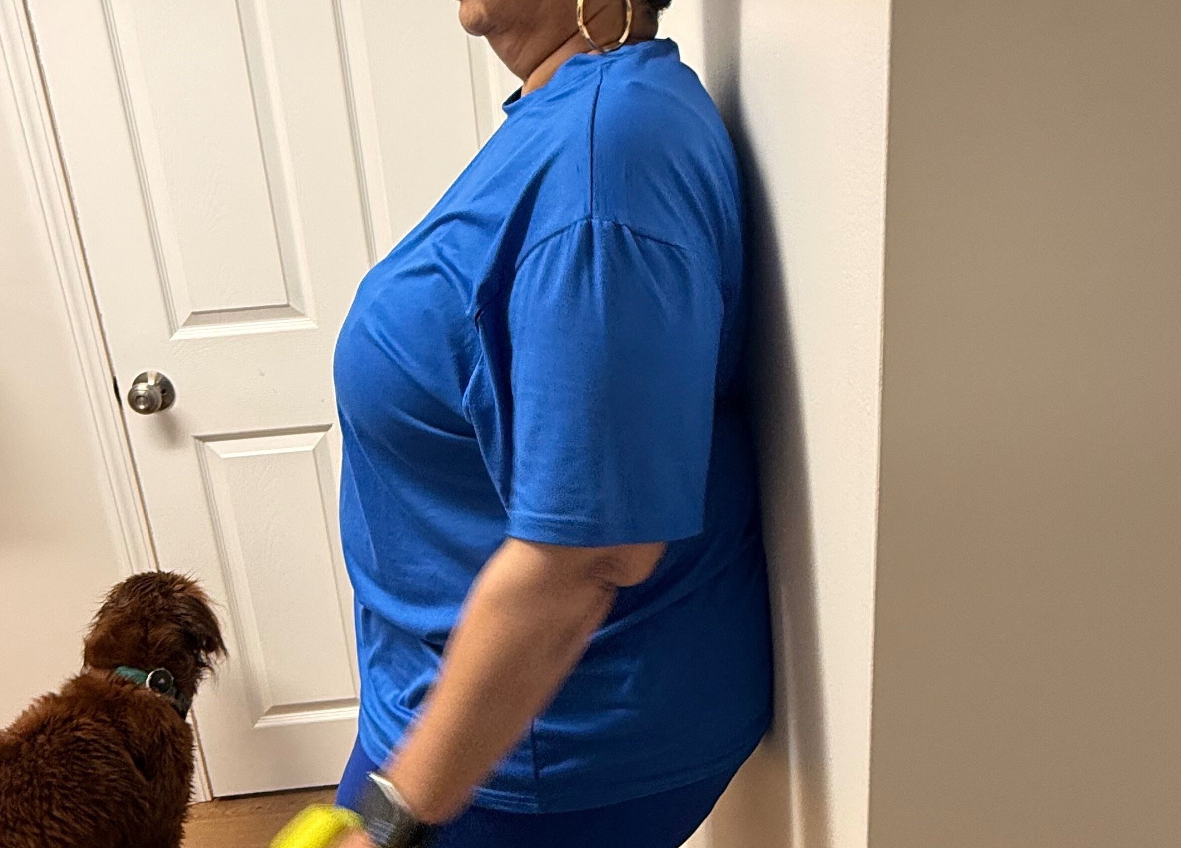 Person relaxing against a wall at Marks Peak Form, Howell, Michigan, US, with a dog nearby.