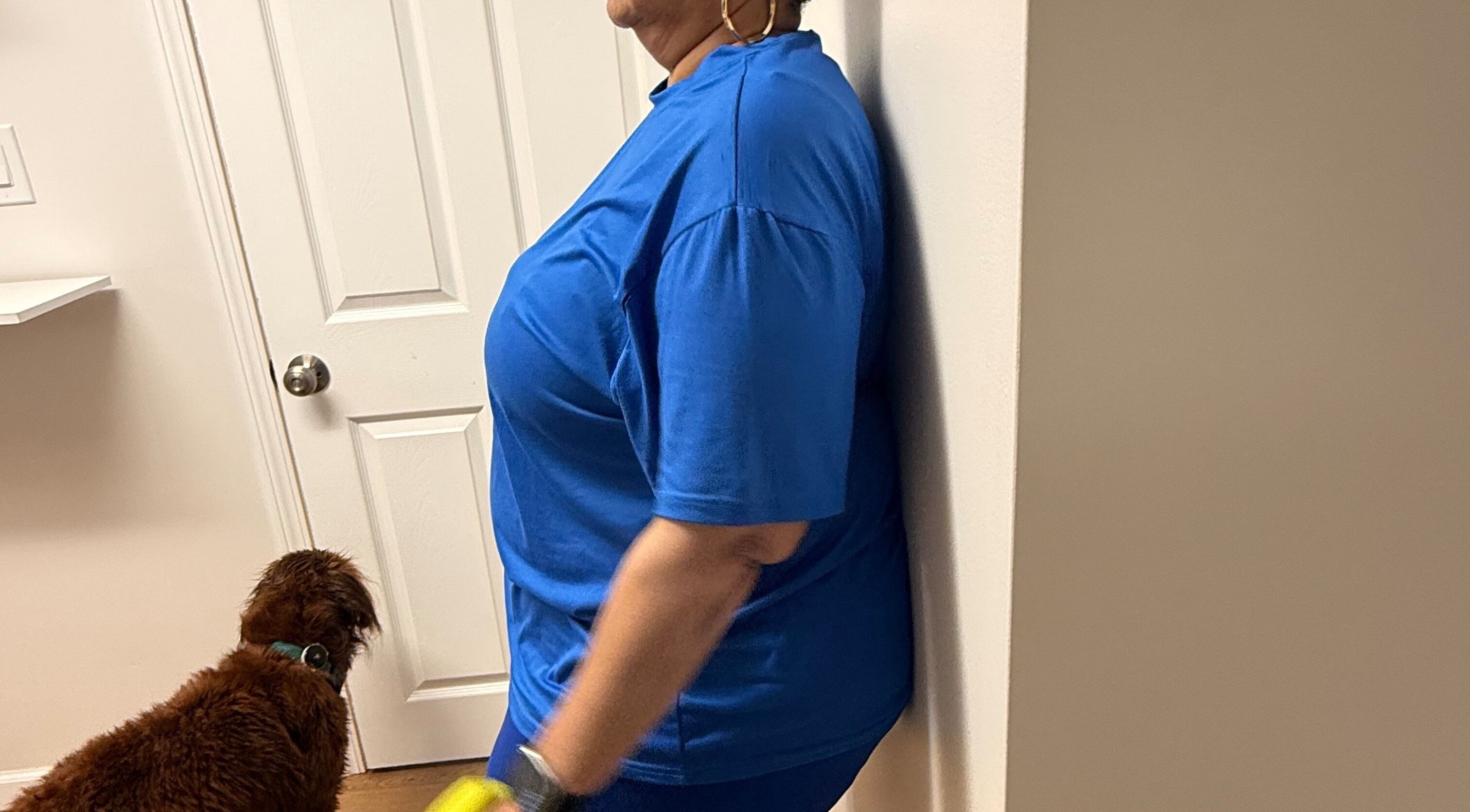Person relaxing against a wall at Marks Peak Form, Howell, Michigan, US, with a dog nearby.