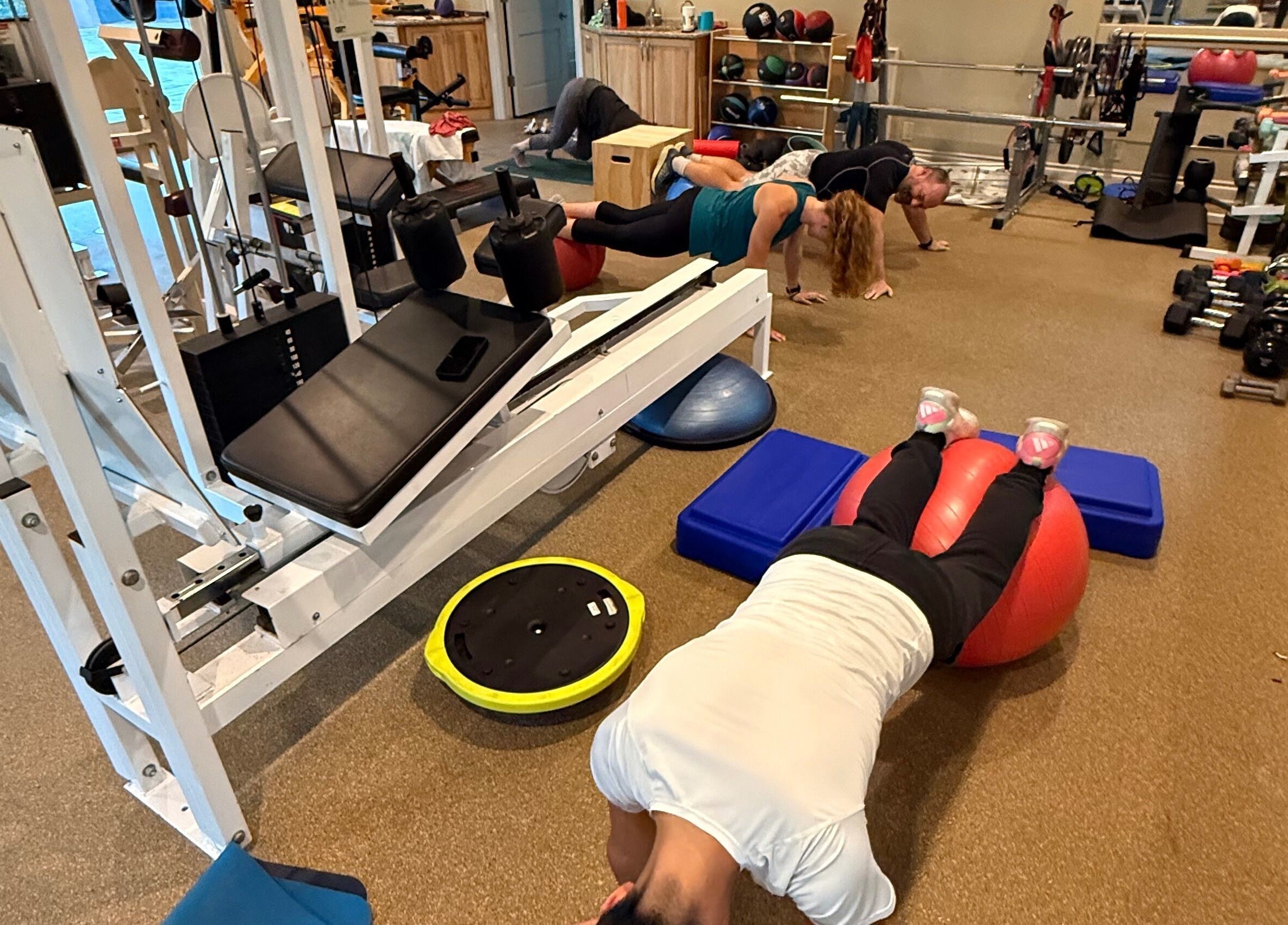Guests exercising at Marks Peak Form, a wellness center in Howell, Michigan, US, surrounded by gym equipment.