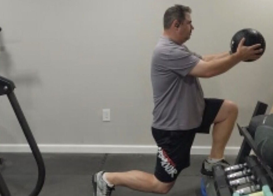 Person practices core exercise with a medicine ball at Marks Peak Form, Howell, Michigan, US.