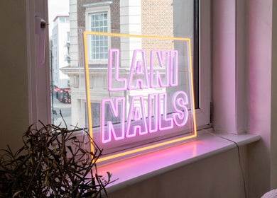 Neon sign saying 'Lani Nails' in London, GB window. Vibrant glow enhances the beauty venue.