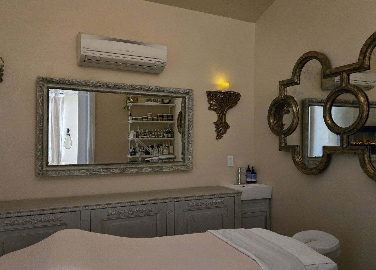 Calm treatment room at Opal Spa and Boutique in Santa Cruz, California with elegant decor and plush bed.