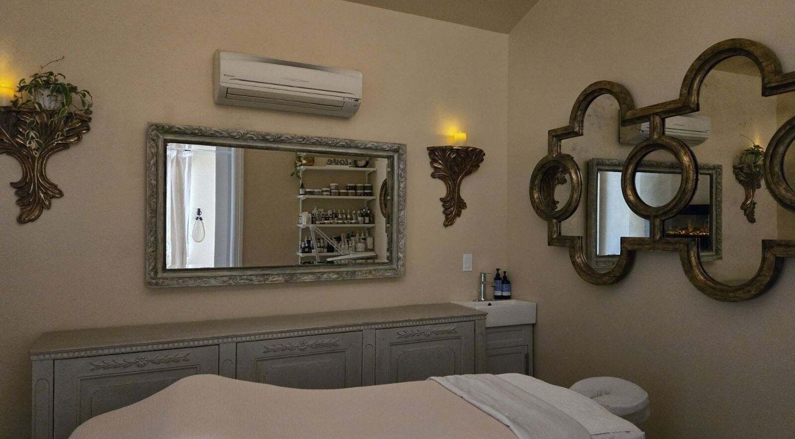 Calm treatment room at Opal Spa and Boutique in Santa Cruz, California with elegant decor and plush bed.