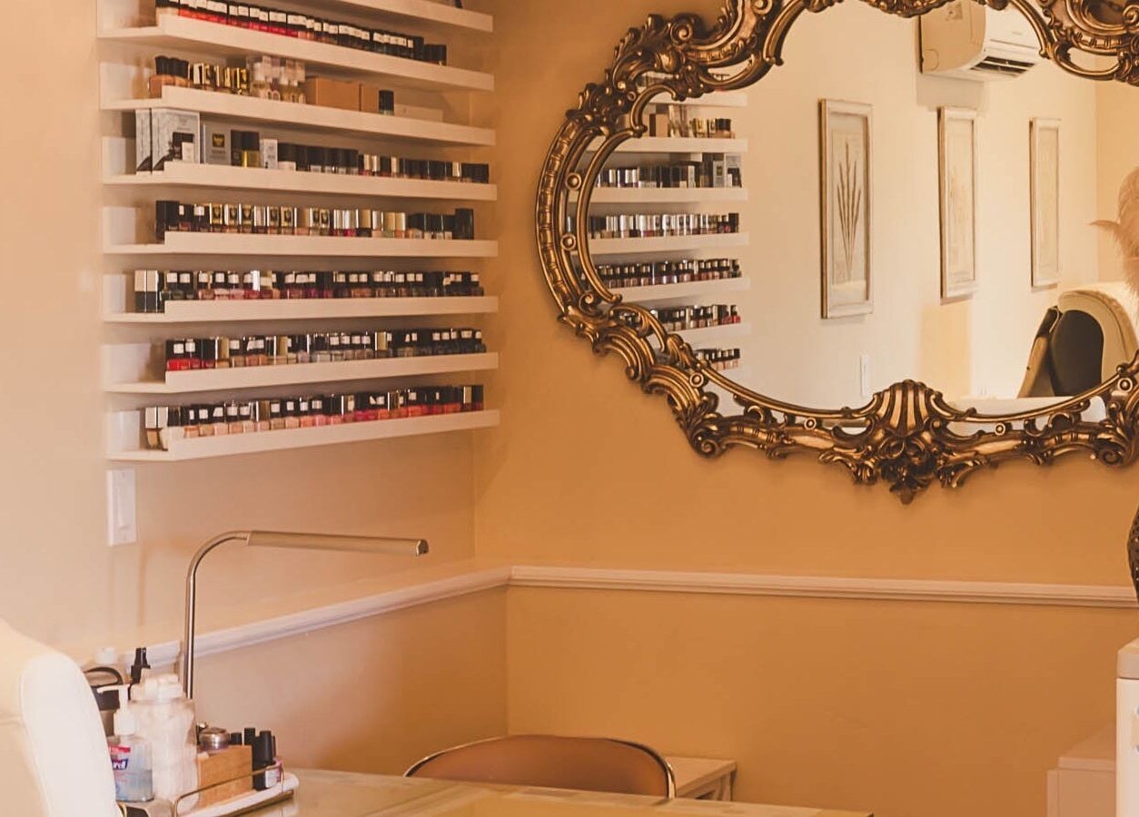 Chic nail polish display at Opal Spa and Boutique, Santa Cruz, California, US, featuring ornate mirror.