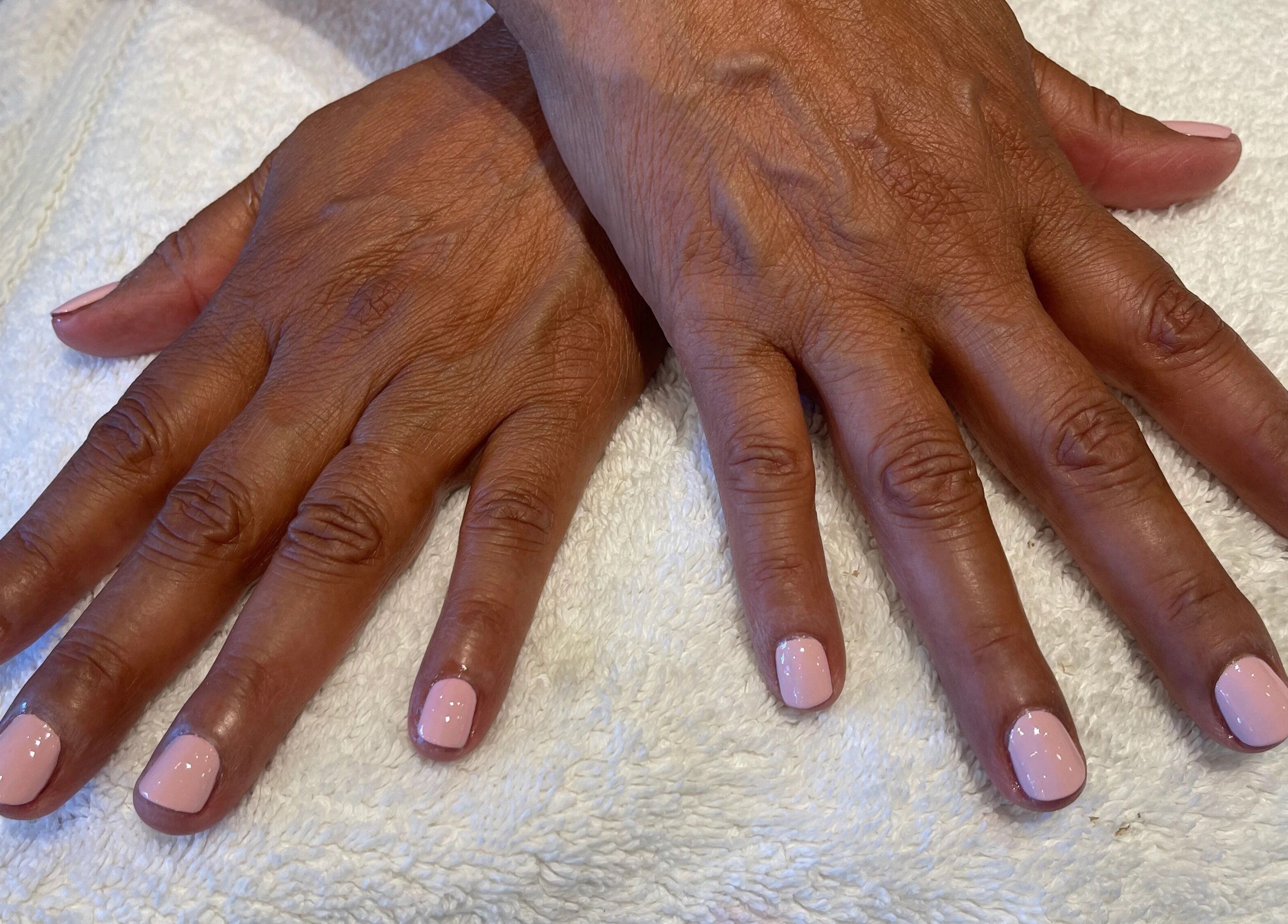 Freshly manicured hands with pink nails at Opal Spa and Boutique, Santa Cruz, California, US.