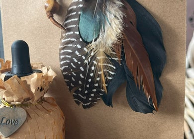 Decorative feathers and a rustic bottle adorn Lil’Ohana Massage - Mini Tropical Escape, Southport, Queensland, AU.