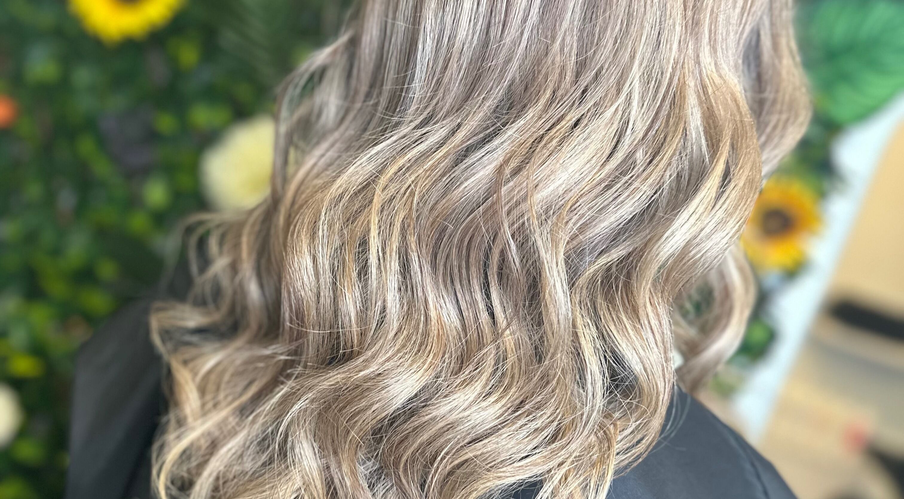 Blonde waves styled at Thistles by Bethany Danielle Hair in Carlisle, England, GB with a floral backdrop.