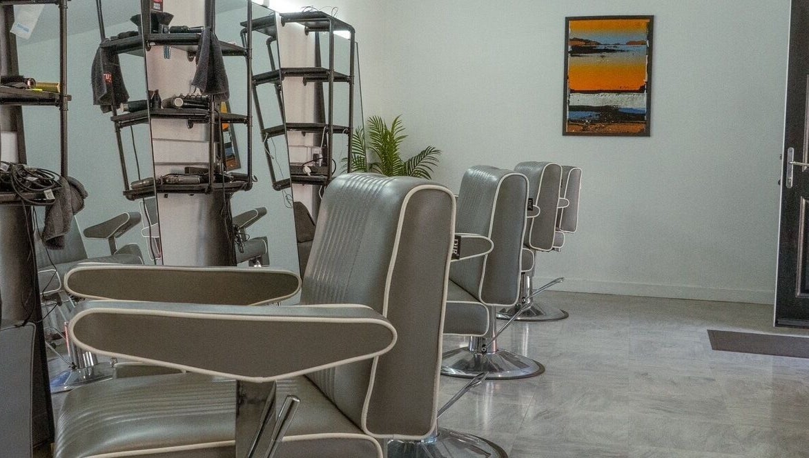 Chic interior of STUDIO26 Barbershop featuring modern chairs in Hazel Grove, England, GB.