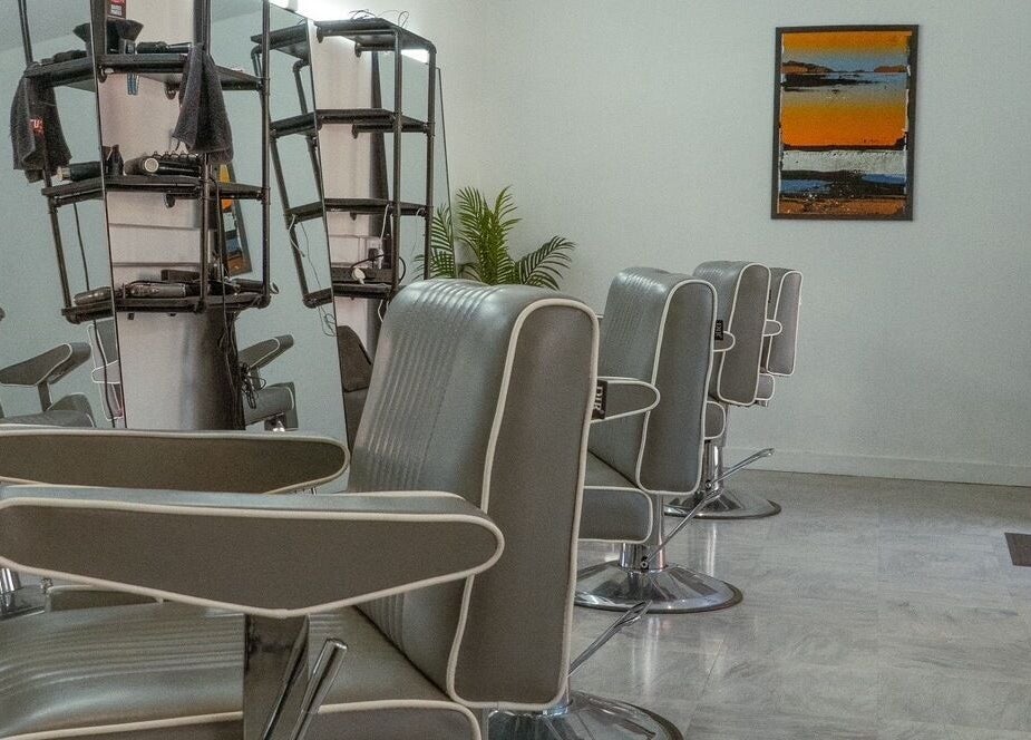 Chic interior of STUDIO26 Barbershop featuring modern chairs in Hazel Grove, England, GB.