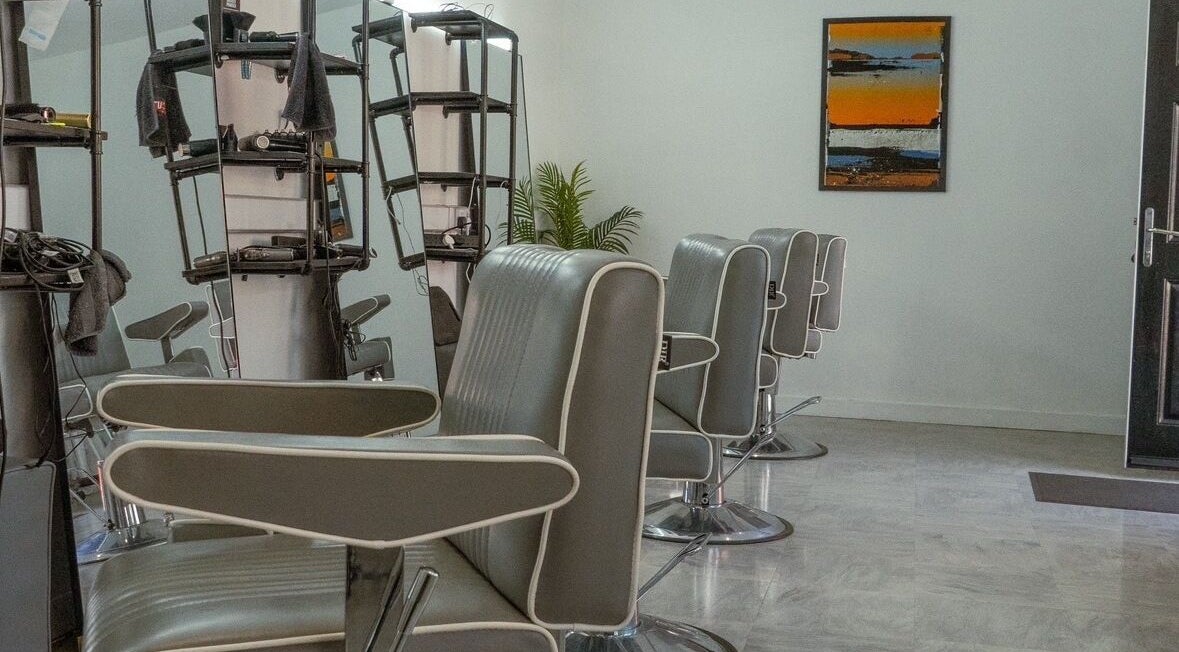 Chic interior of STUDIO26 Barbershop featuring modern chairs in Hazel Grove, England, GB.