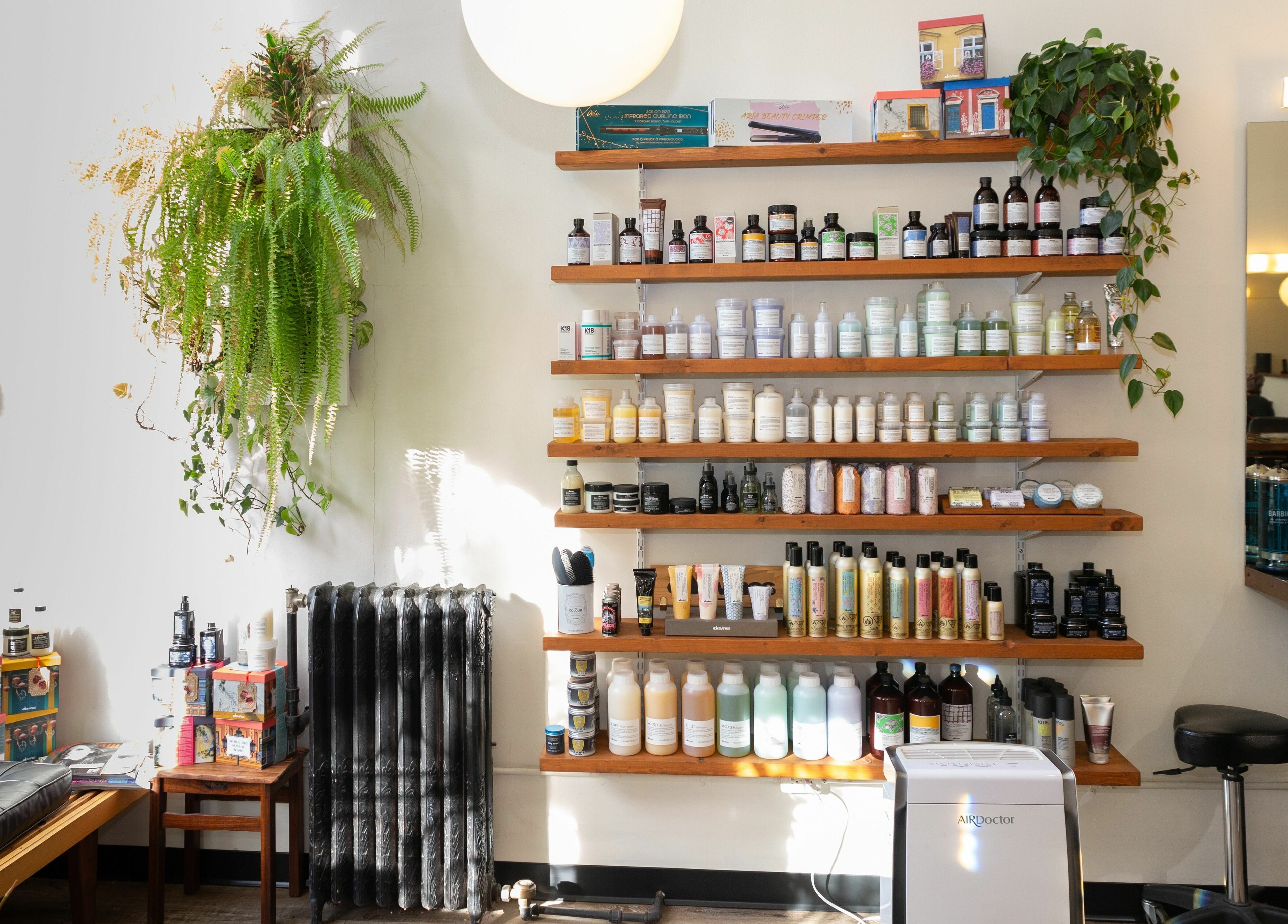 Colourbox venue shelves in Vancouver, BC, displaying a variety of beauty products with lush green plants.