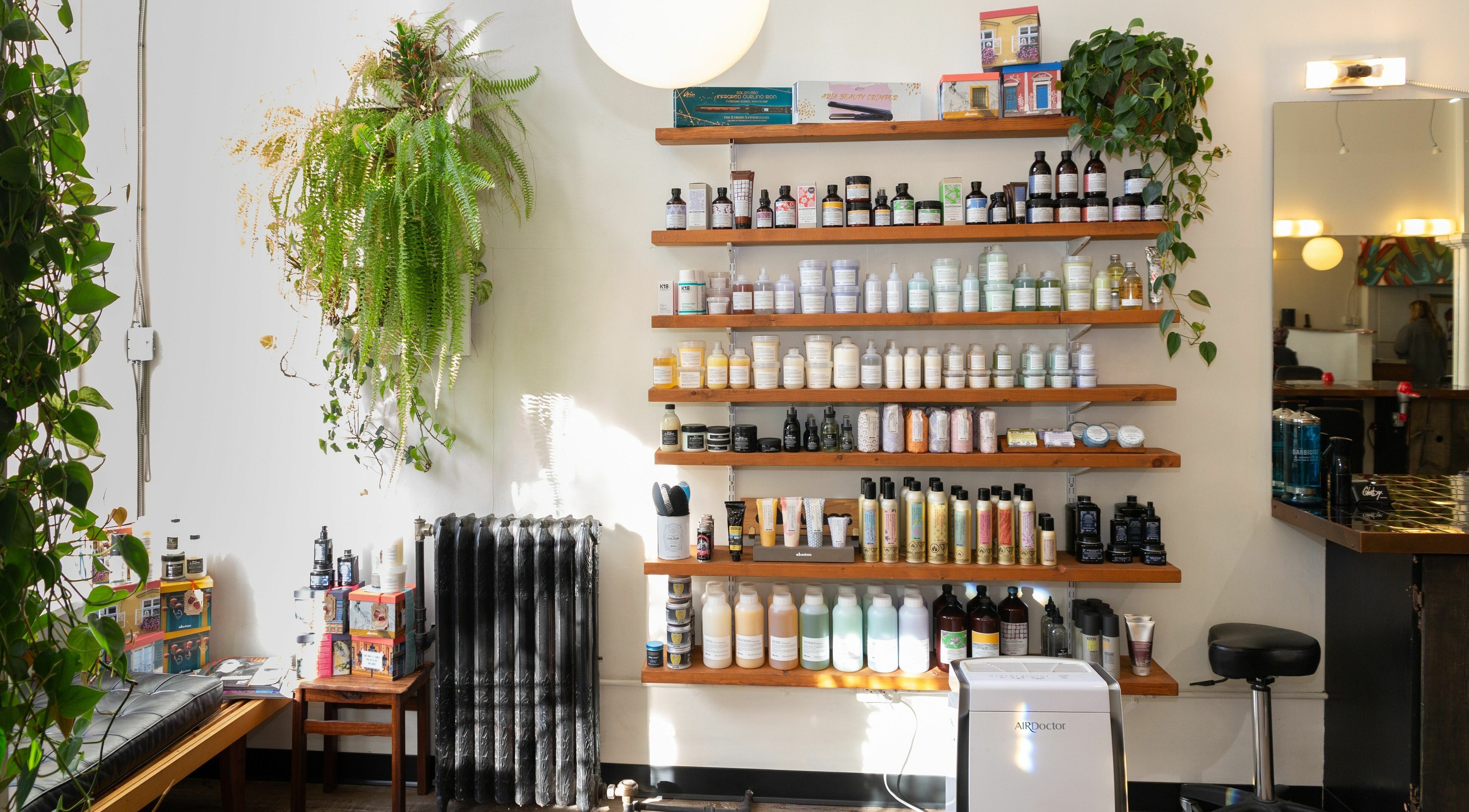 Colourbox venue shelves in Vancouver, BC, displaying a variety of beauty products with lush green plants.