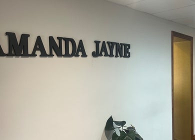 Amanda Jayne Hairdressing entrance sign in Swalwell, England, GB with decorative plants.