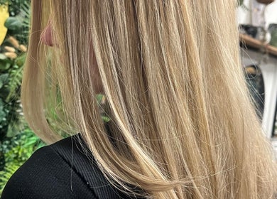 Elegant blonde hairstyle at Amanda Jayne Hairdressing, Swalwell, England, GB, enhanced by lush green decor.