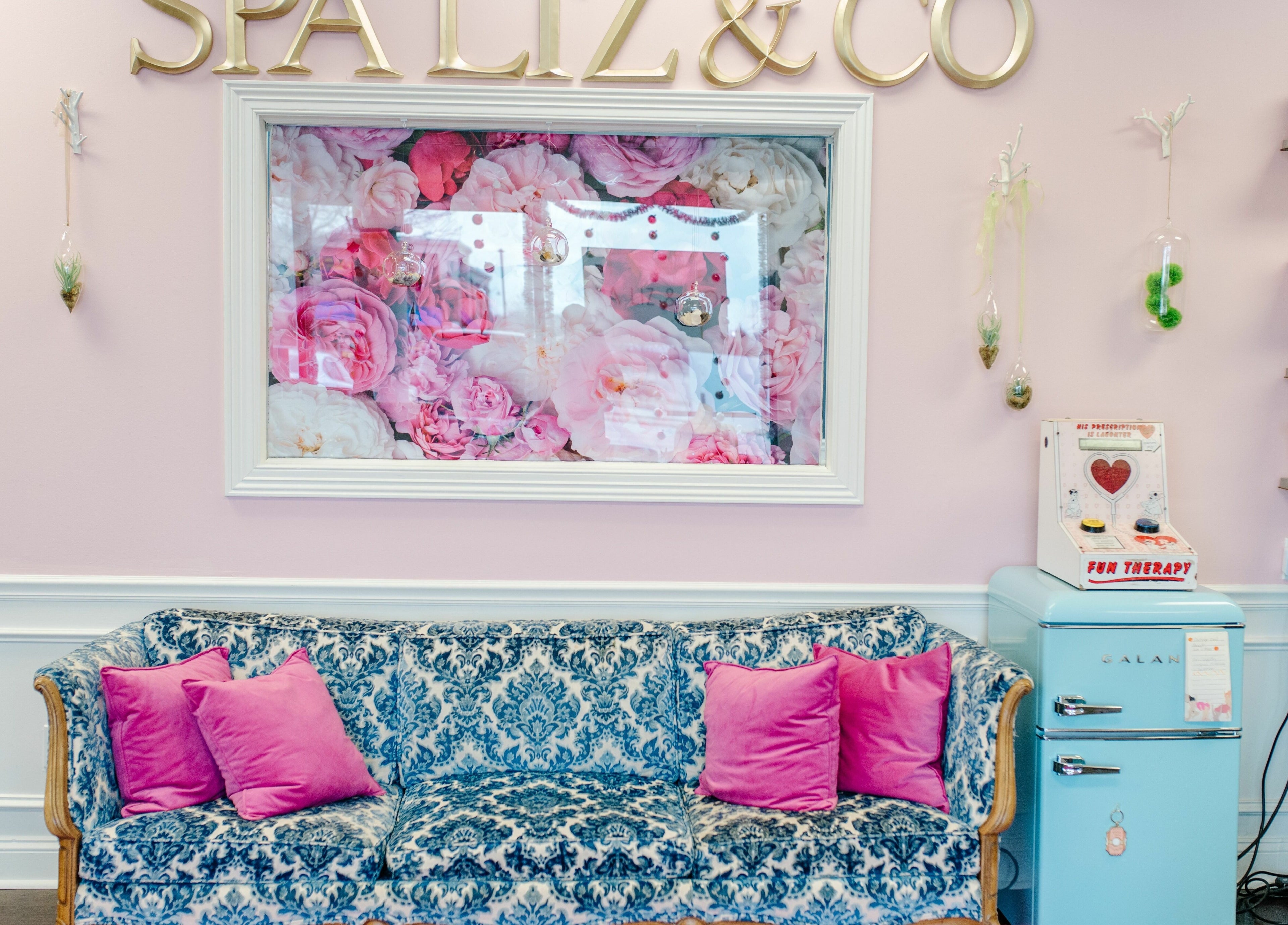 Elegant lounge area at Spa Liz and Co. in Greenfield, Wisconsin, US with floral decor and plush seating.