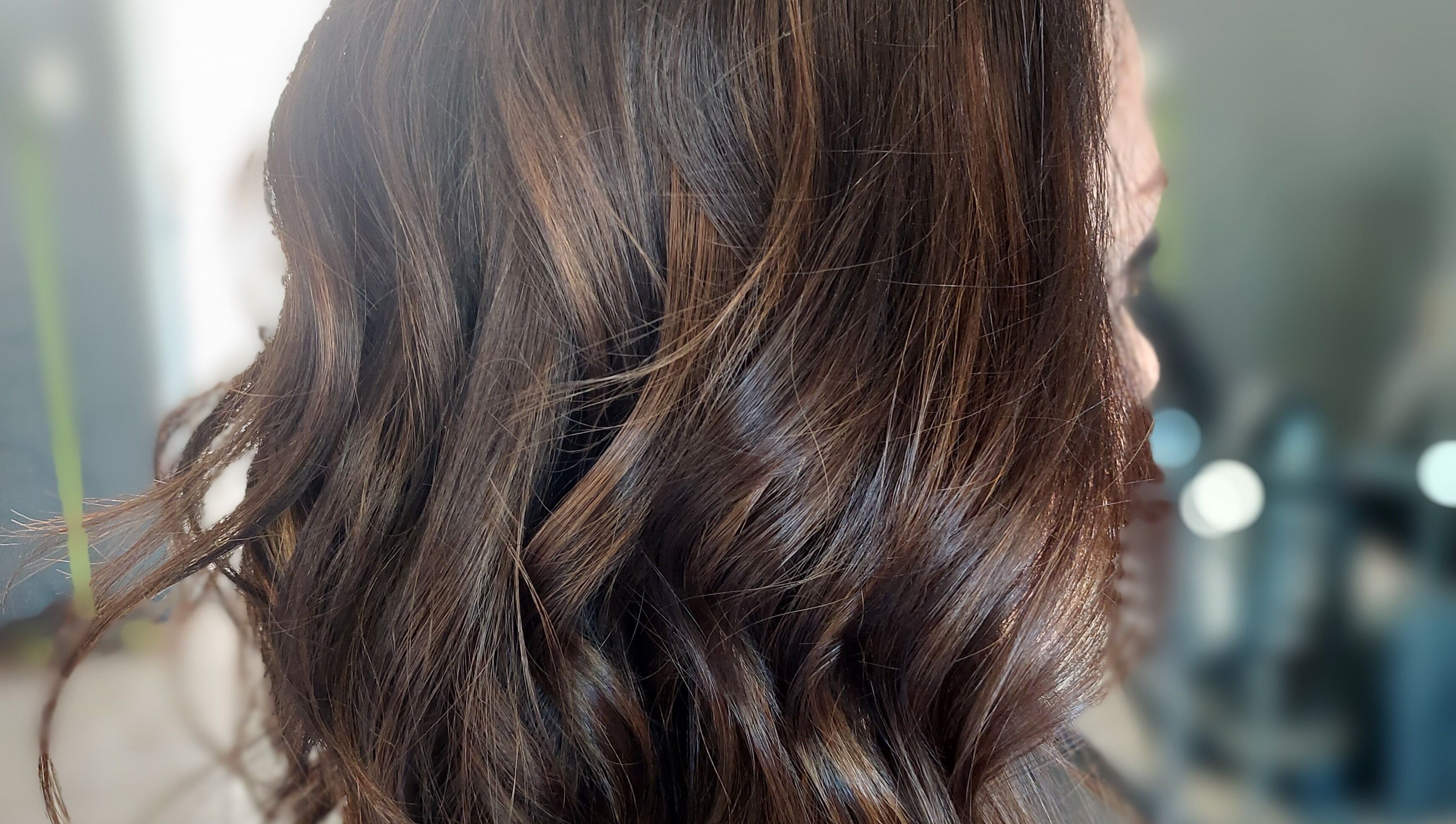 Rich, wavy brown hair styled at Beyond the Chair, Pretoria, Gauteng, ZA in a sleek, professional look.