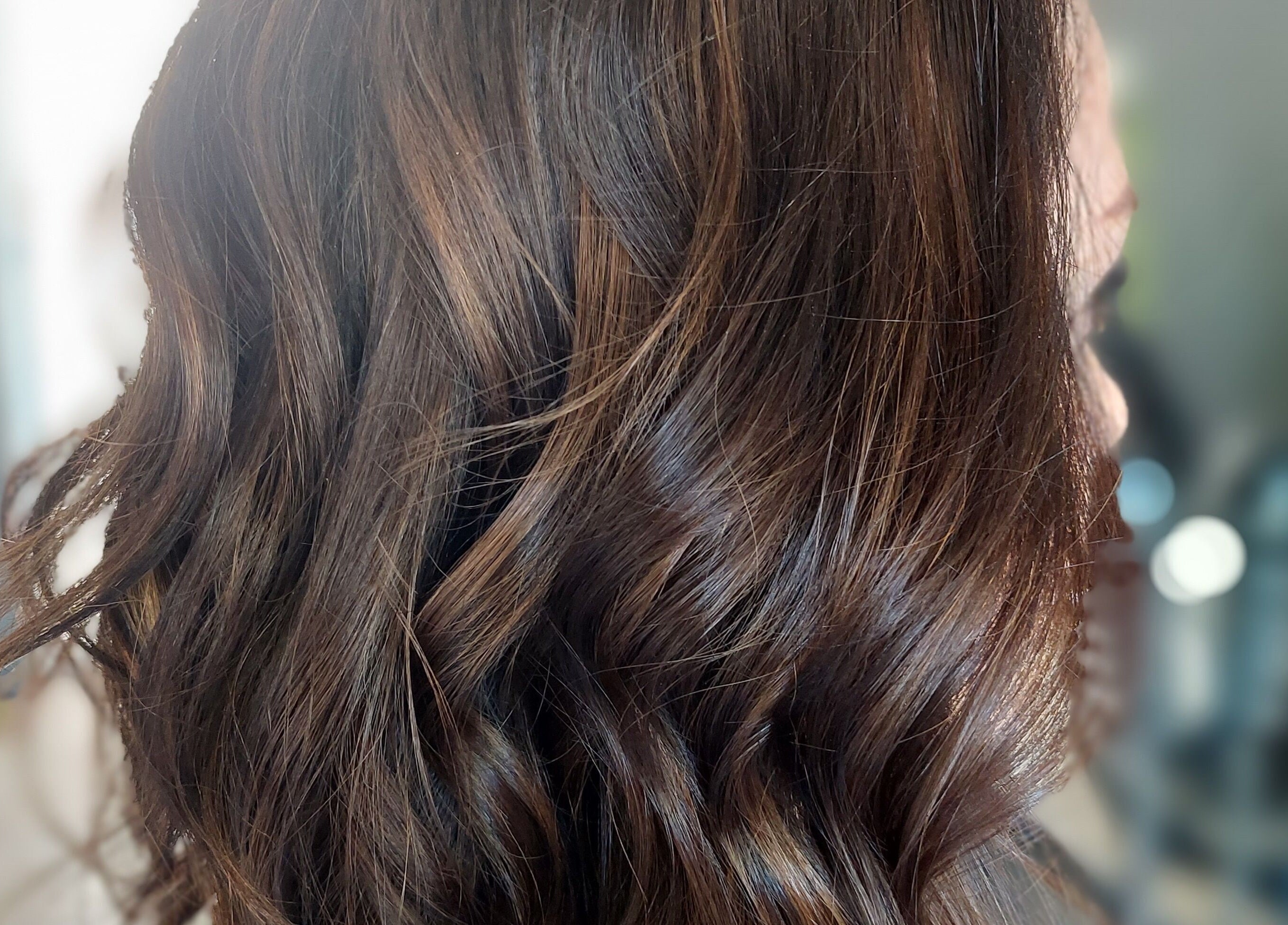 Rich, wavy brown hair styled at Beyond the Chair, Pretoria, Gauteng, ZA in a sleek, professional look.