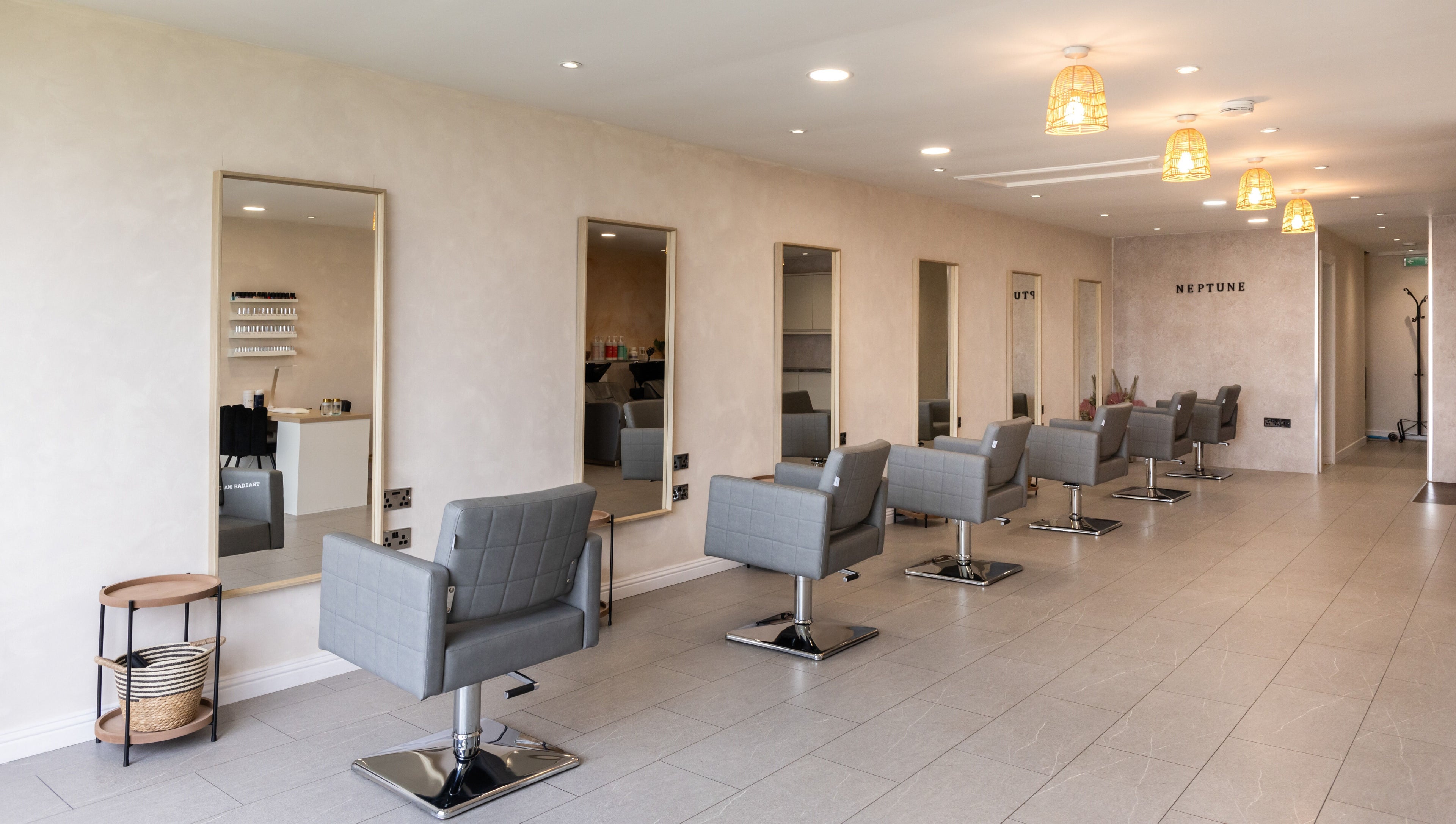 Stylish salon interior at Neptune, Livingston, Scotland, GB with grey chairs and modern decor.