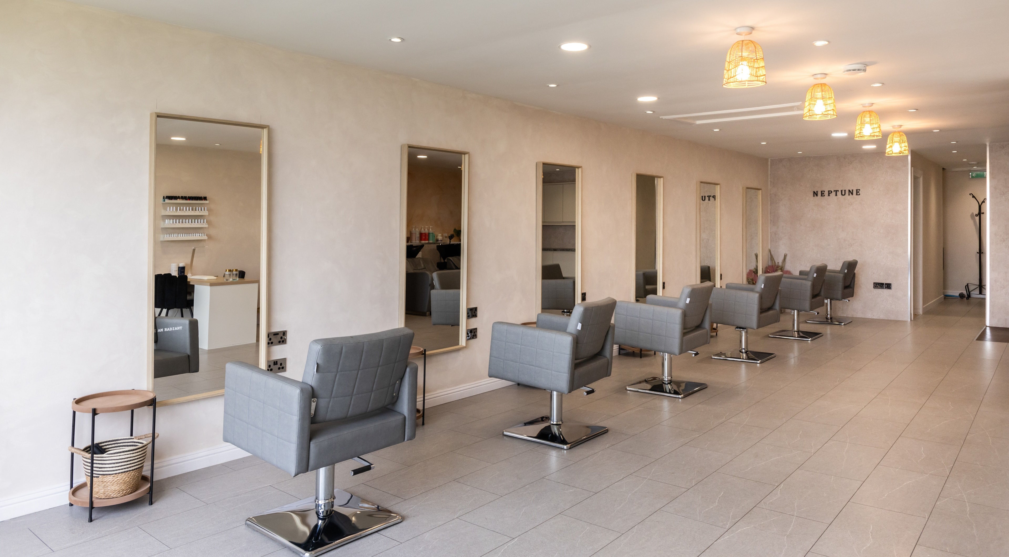 Stylish salon interior at Neptune, Livingston, Scotland, GB with grey chairs and modern decor.