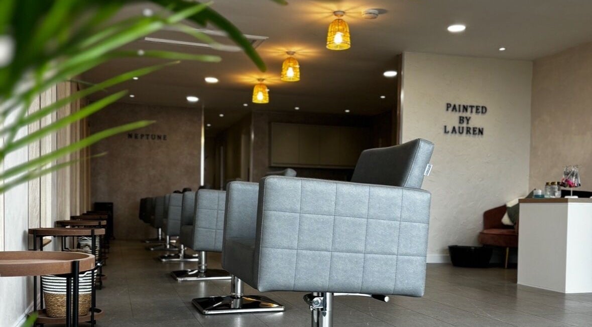 Modern salon interior at Neptune in Livingston, Scotland. Elegant seating and warm lighting create inviting atmosphere.