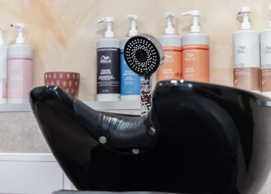 Modern black shampoo bowl at Neptune salon in Livingston, Scotland, GB with product lineup.