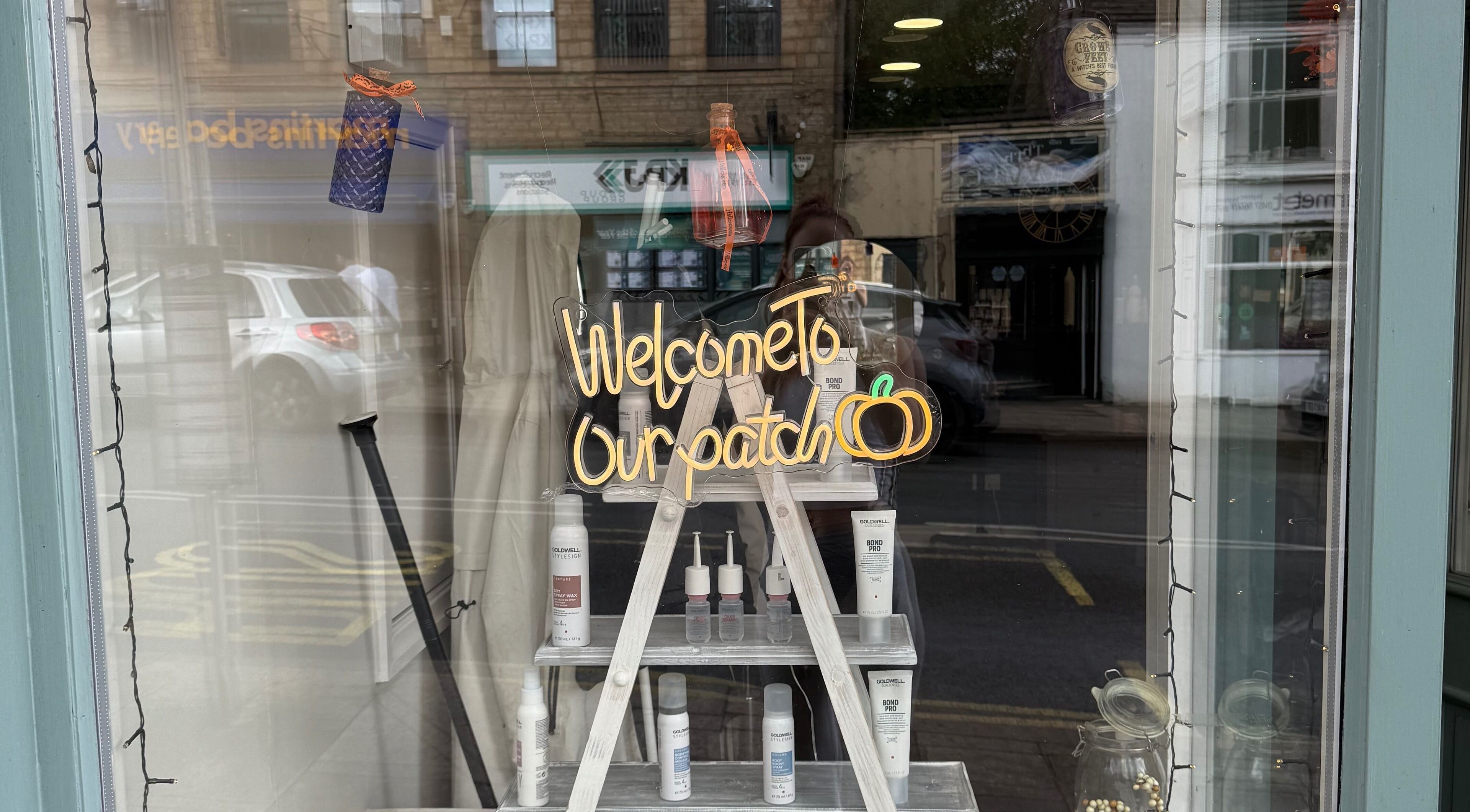 Chic window display at Kendrick and Whyatt Hair Studio, Glossop, England, GB, featuring a 'Welcome' sign.