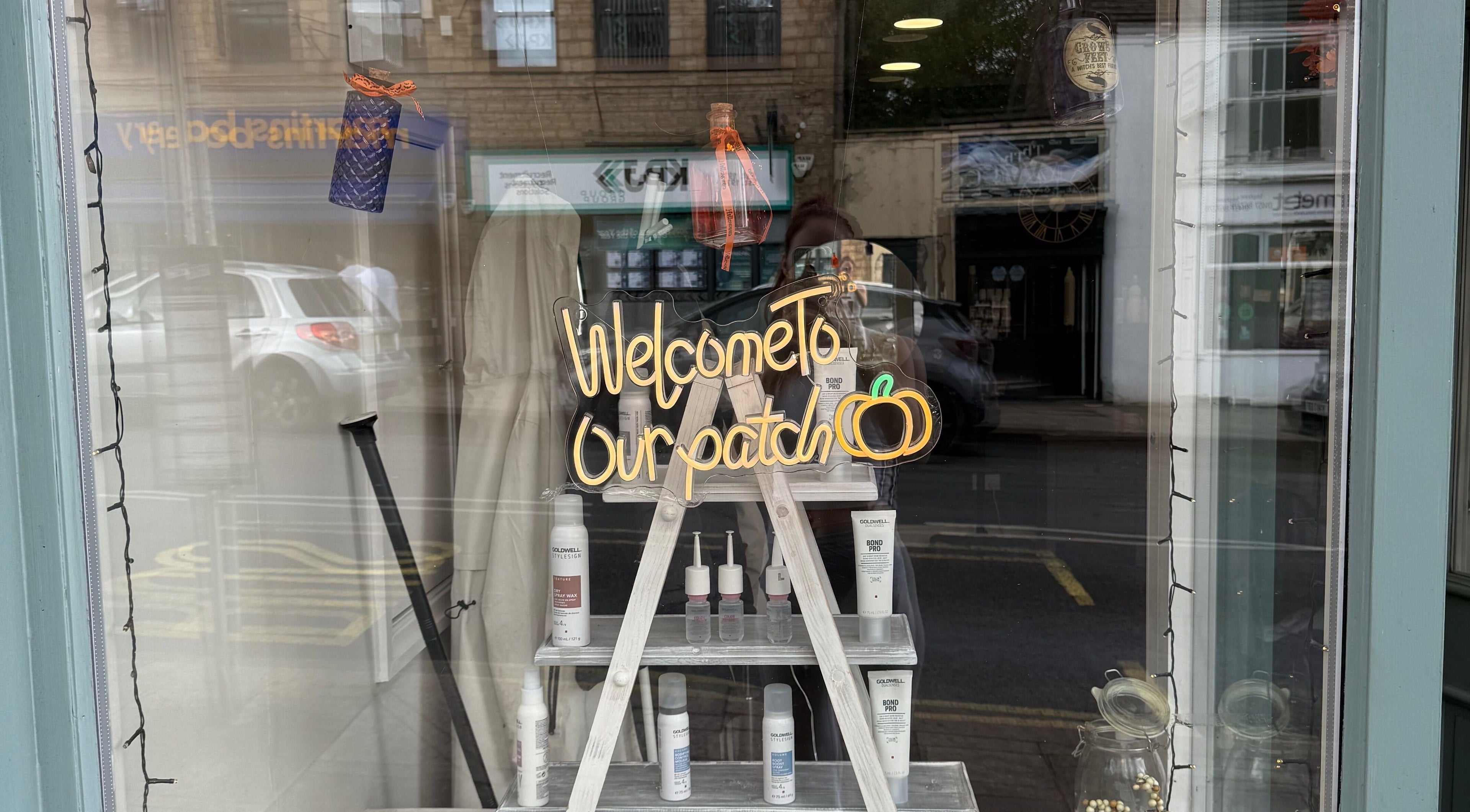 Chic window display at Kendrick and Whyatt Hair Studio, Glossop, England, GB, featuring a 'Welcome' sign.