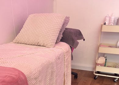 Cozy treatment room at All About You, St Austell, England, GB with soft blankets and skincare products.