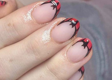 Close-up of trendy red and black nail art at All About You, St Austell, England, GB.