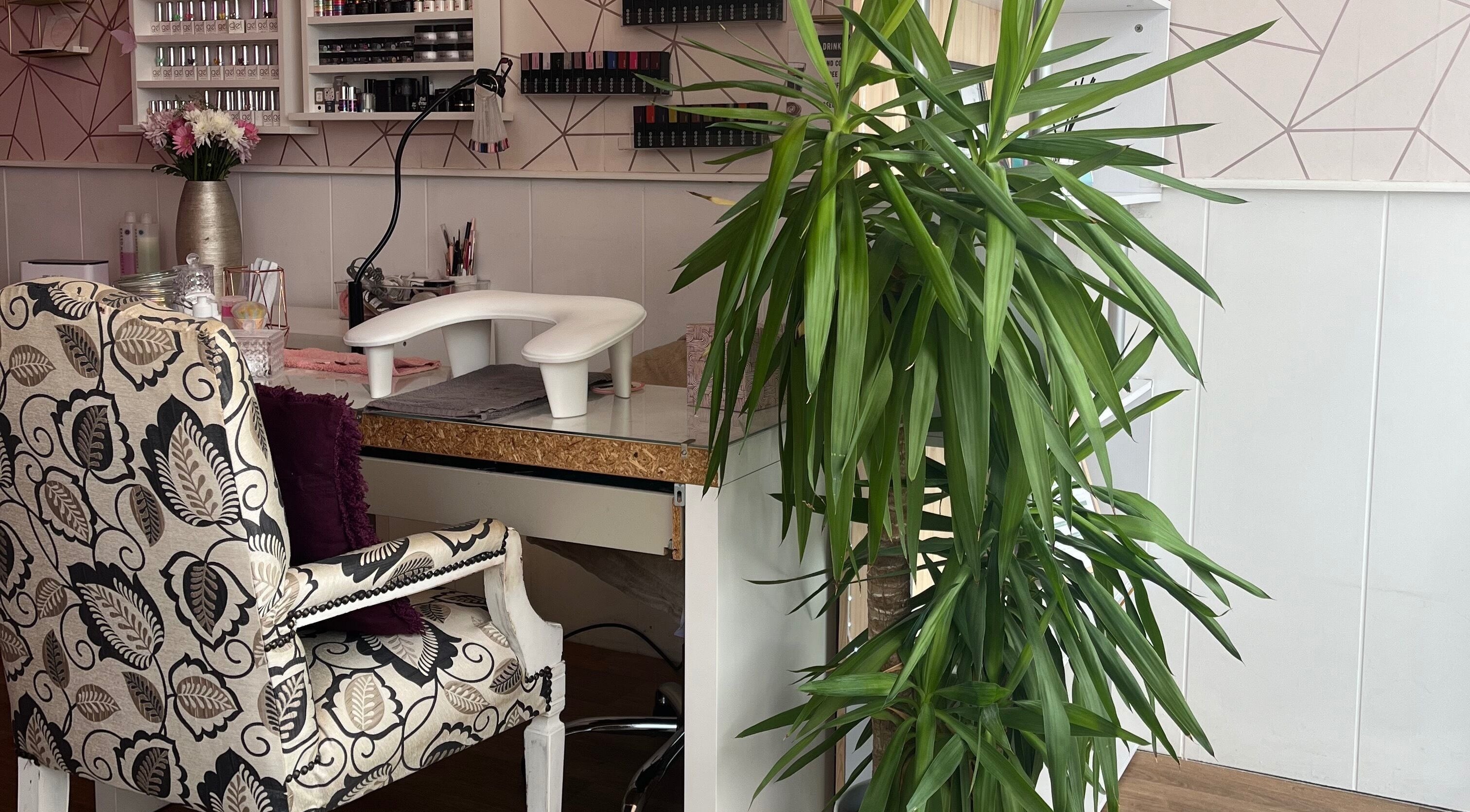 Elegant beauty salon corner at All About You, St Austell, England, GB with patterned chair and lush plant.