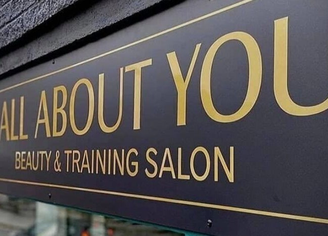 Elegant sign of All About You Beauty Salon and Training Academy in St Austell, England, GB.