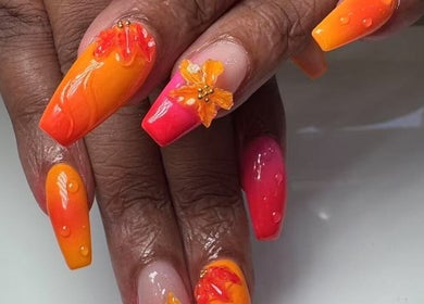 Bright floral nail art at Oasis Nail Spa Windermere in Orlando, Florida, US, showcasing orange and pink hues.