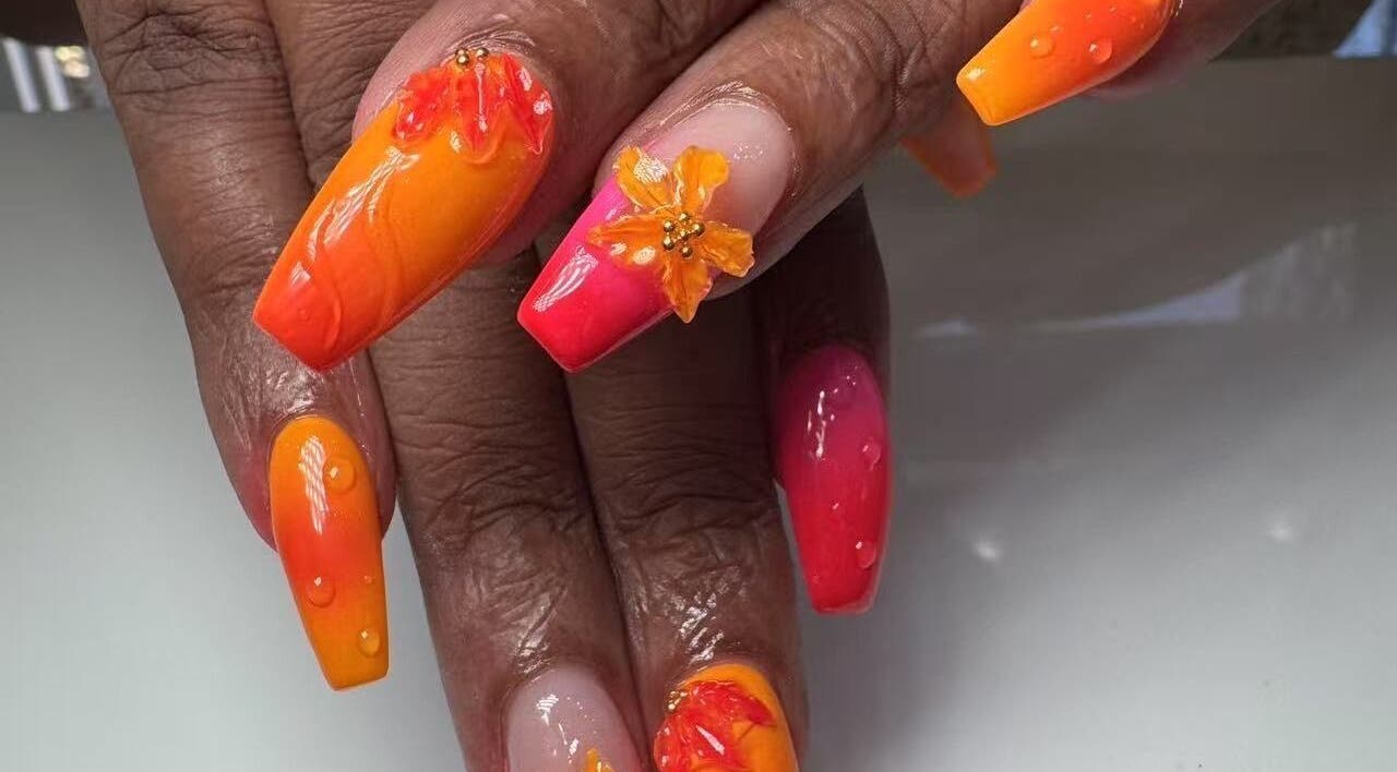 Bright floral nail art at Oasis Nail Spa Windermere in Orlando, Florida, US, showcasing orange and pink hues.