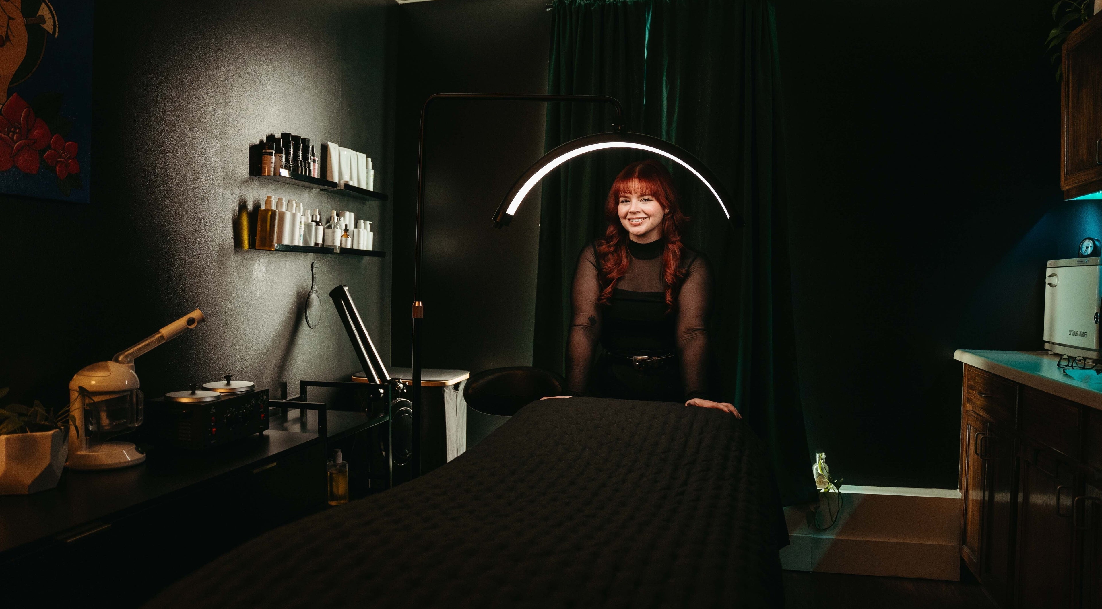 Warm and inviting treatment room in Valiant Skin Studio, Tulsa, Oklahoma, US, featuring a smiling therapist.
