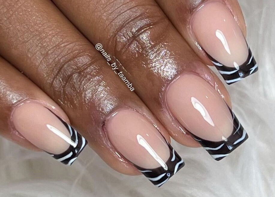 Stylish zebra French tip nails by Nails by Taamba in Windhoek, Khomas Region, NA on a fluffy white background.