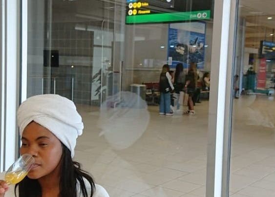 A woman enjoying a drink at Herspace Wellness PE Airport SPA in Gqeberha, Eastern Cape, ZA.