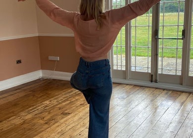 A person practices yoga at The Retreat New Forest, Christchurch, Dorset, GB, with serene garden views.