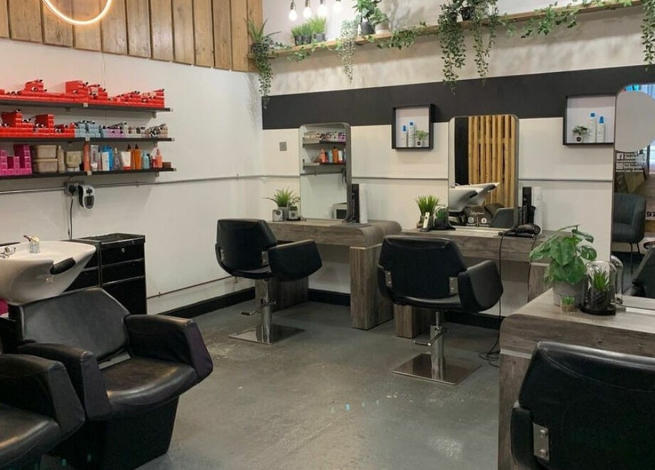 Modern salon interior at Eden, Sheffield, England, GB, featuring sleek styling stations and lush greenery.