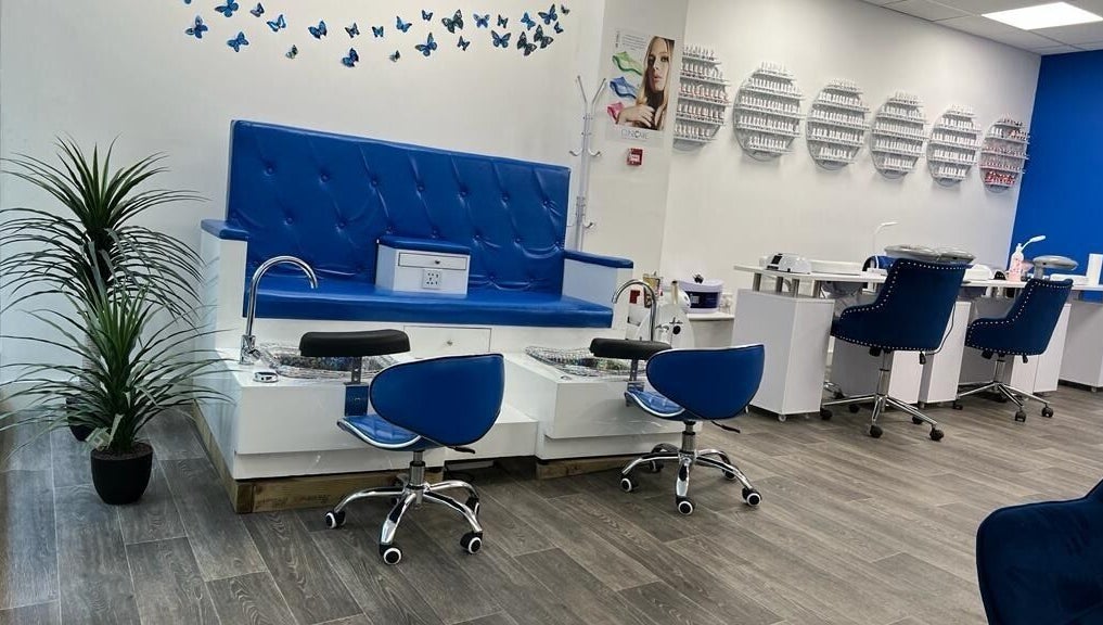 Elegant pedicure area at Beautifly, Romford, England, GB, featuring blue seating and nail polish display.