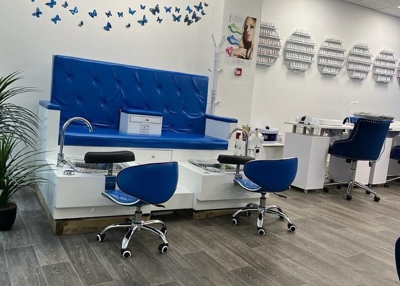 Elegant pedicure area at Beautifly, Romford, England, GB, featuring blue seating and nail polish display.
