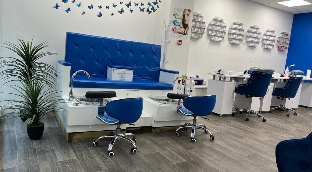Elegant pedicure area at Beautifly, Romford, England, GB, featuring blue seating and nail polish display.