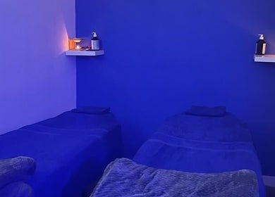 Relaxing blue therapy room at Beautifly, Romford, England, GB, featuring two treatment beds.