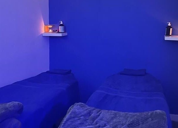 Relaxing blue therapy room at Beautifly, Romford, England, GB, featuring two treatment beds.