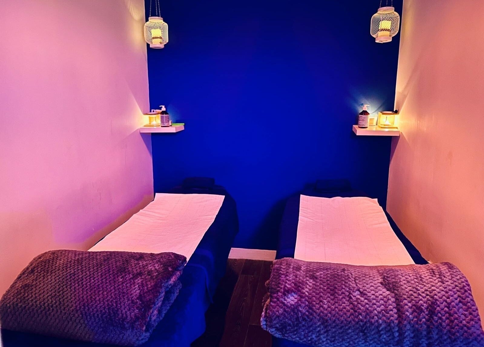 Relaxing treatment room at Beautifly, Romford, England, GB with two massage tables under soft lighting.