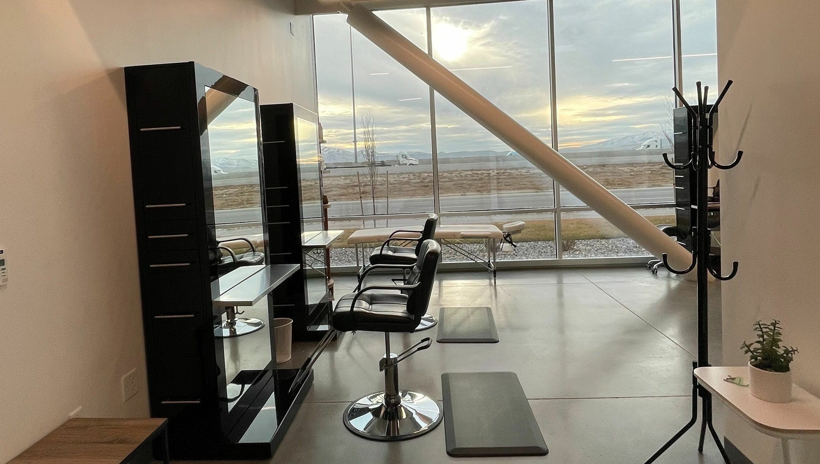Modern interior of Weave Salon in Lehi, Utah, US with stylish chairs and large windows showing a scenic view.